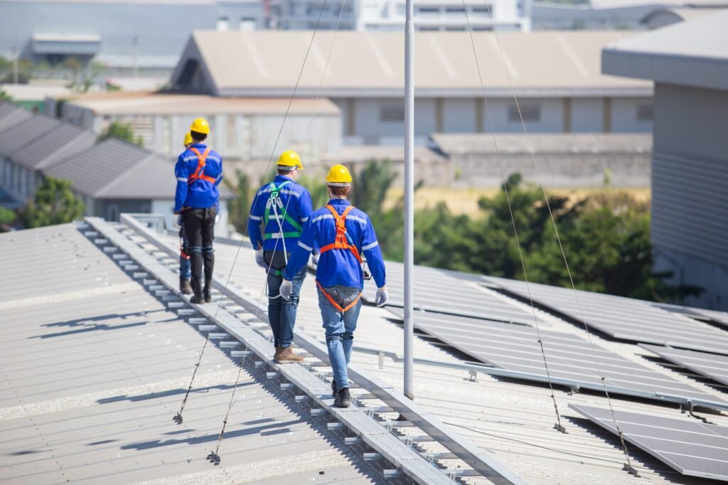 Engineer set installing and inspect standards of solar panels on roof of an industrial factory.